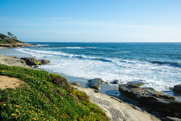 Fototapeta na wymiar Rocky and foamy ocean shore in San Diego