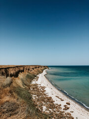 cliff sea blue aquamarine waves line sunny beach. Soft wave of ocean foam.