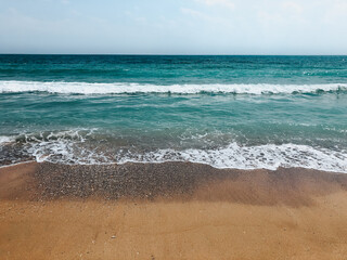 Sea blue aquamarine waves line sunny sand beach. Soft wave of ocean foam.