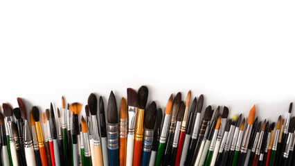 Mix of paint brushes in a row isolated on a white background.