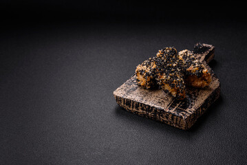 Delicious fresh crispy chicken or fish nuggets on a dark concrete background