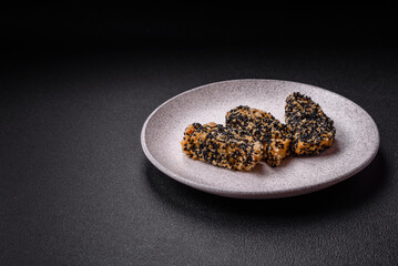 Delicious fresh crispy chicken or fish nuggets on a dark concrete background