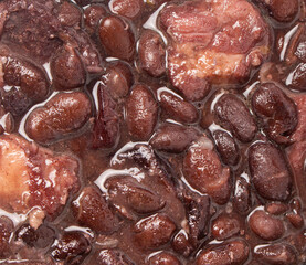 Close up on Brazilian Feijoada, with black beans, pork and bacon. Brazilian popular food.