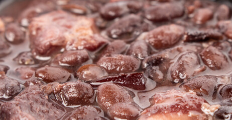 Close up on Brazilian Feijoada, with black beans, pork and bacon. Brazilian popular food.