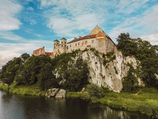 Fototapeta na wymiar Aerial view of Benedictine abbey of Saints Peter and Paul in Tyniec, Poland. Stone building of medieval catholic monastery, stronghold with towers and church on scenic river bank near Krakow