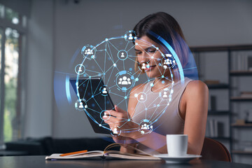 Fototapeta na wymiar Smiling businesswoman in casual wear holding tablet device touching it at office workplace. Concept of distant work, business education, information technology. Social network abstract hologram