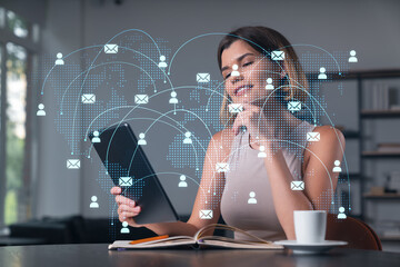 Smiling businesswoman in casual wear holding tablet device touching it at office workplace. Concept...