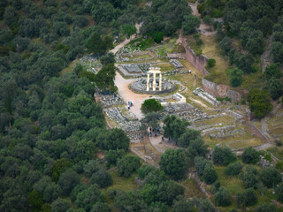 Aerial, panoramic view of illuminated ancient temple complex of Athena Pronaia in Delphi. Archaeological site, UNESCO World Heritage Site.
