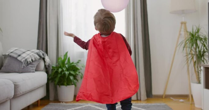 Child Superhero Playing with Balloons Indoors