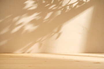 Wooden table mockup and plaster wall background with window and leaves shadow on the wall. Mock up...