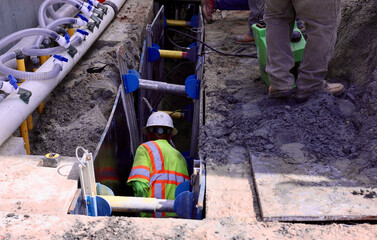 maintenance engineer working in a deep trench with shoring