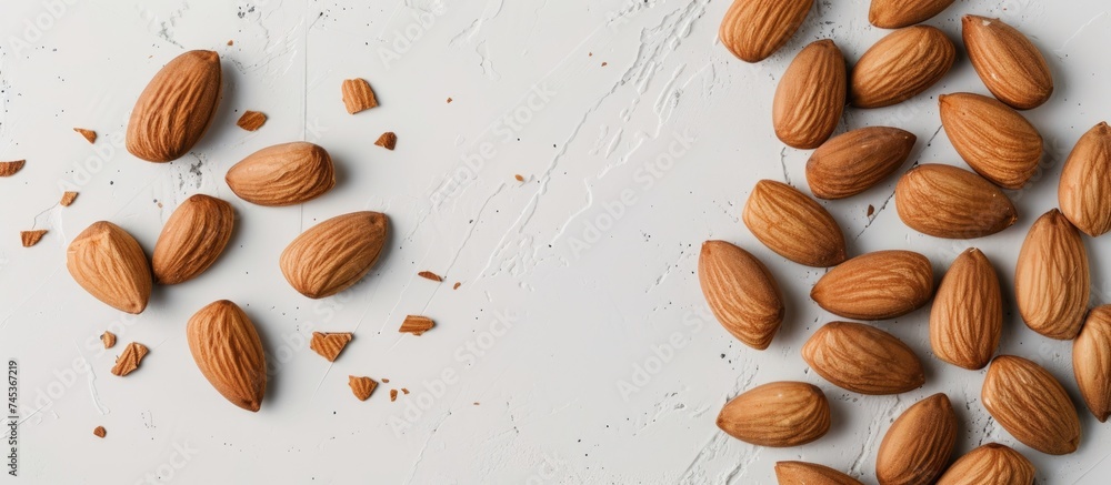 Poster a collection of almond kernels neatly stacked on top of a clean white table surface. the almonds are