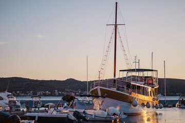Sailboat in glow of sunlight moored at pier of Biograd na Moru port in Croatia