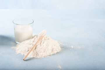 Milk in a glass jug with a pile of wheat flour next to it