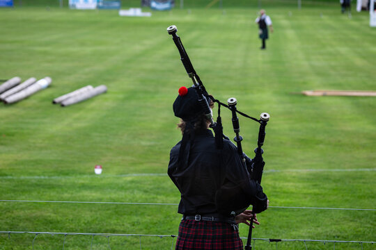 A Scottish bagpiper plays his bagpipes on the playing field of the Scottish Highland Games in the town of Crieff in Scotland