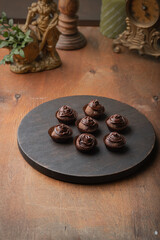 Chocolate truffles on a dark tray on a festive table in vintage style