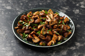 Delicious fried mushrooms with herbs and parsley in plate.