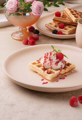 Viennese waffles with berry sauce and cream on a light background