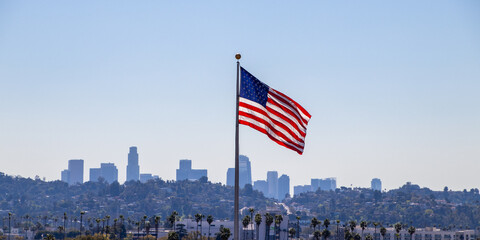 USA Flag flying with Los Angeles skyline in background