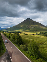 Aerial view of the A82 road as it passes through Bridge of Orchy with the mountains. Highlands Scotland