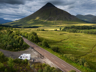 A motorhome with tourists travels on the A82 road as it passes Bridge of Orchy in the mountains of...