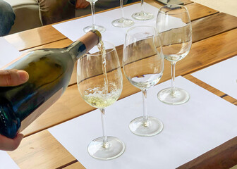 Pouring white wine at a wine tasting