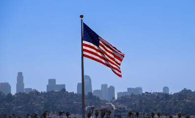 USA Flag flying with Los Angeles skyline in background