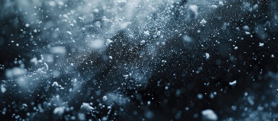 Snowflakes gracefully falling on a black and white canvas, resembling abstract water splashes. The...