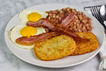 fried egg served with corn beef hassh and bacon