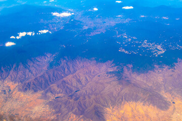 Fototapeta na wymiar Flying airplane over Mexico Clouds Sky Volcanoes Mountains City desert.