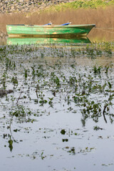 Wooden green colored fishing boat on the lake, reflection of the boat on the water. Authentic wooden boat.. Sazlidere Lake, Istanbul, Turkey.