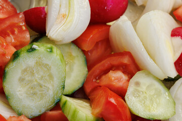 Ensalada aliñada de tomate, pepino, cebolla y rabano. Preparada para comer.