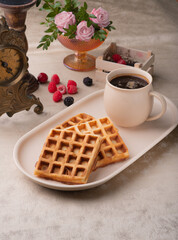 Two Viennese waffles on a beige dish on a table