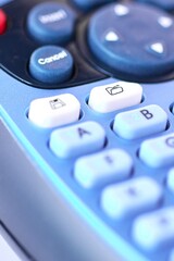 Detailed image of a blue electronic labeling machine for thermal printing ribbon, focusing on the file folder key and everything around it out of focus.