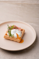 A poached egg cut into a Viennese waffle. Holiday breakfast in vintage style