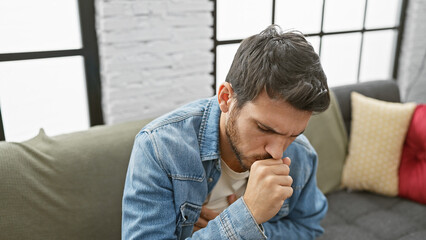 Hispanic man coughing in a modern living room, portraying illness