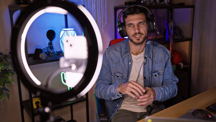Handsome hispanic man with headphones in a gaming room at night