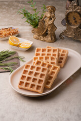 Two Viennese waffles on a beige dish on a table