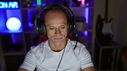 Serious-faced middle age man streamer, immersed in the digital world of gaming inside his home...