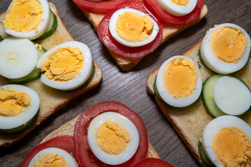 Toasted bread with boiled eggs, tomatoes and cucumber slices 