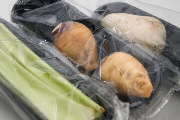 Plastic wrapping protects some pieces of vegetables sold in a supermarket from the outside