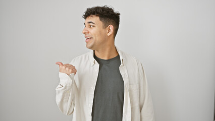A smiling young man with curly hair gestures to his side against a white background.