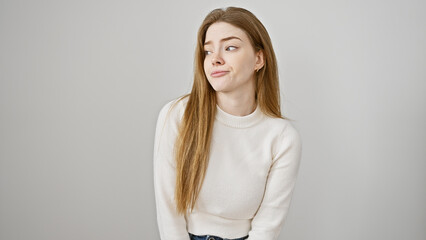 Portrait of a skeptical young woman with long blonde hair, wearing a white sweater against an...