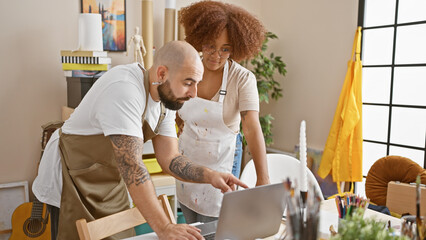 Two passionate artists partnered together, engrossed in an artistic dance of drawing with laptop at...