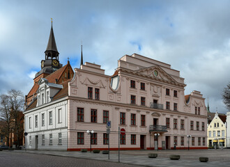 Mit Girlanden verzierte Schmuckfassade am Rathaus von Güstrow, dahinter der Turm der Pfarrkirche...