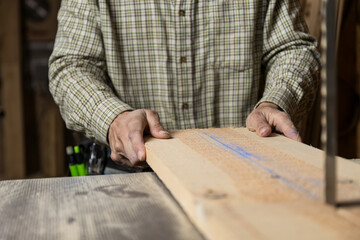 Horizontal photo artisan carpenter using bandsaw in workshop.Copy space. Business concept.