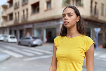 Young african american woman looking to the side with serious expression at street