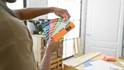 African american man selects swatches in a woodworking workshop