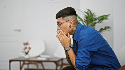 Young latin man sitting on chair at waiting room