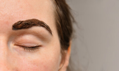 Painted eyebrow on a woman's face close-up, going to a cosmetologist, beauty salon, eyebrow care....
